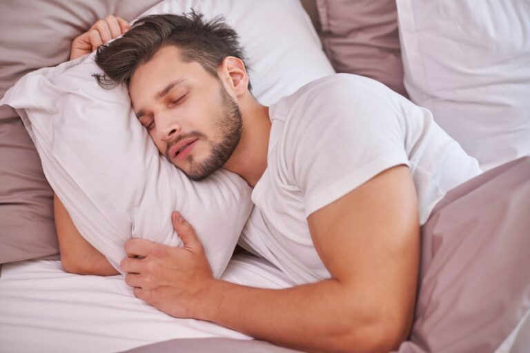 exhausted-man-sleeping-his-bed_329181-3282