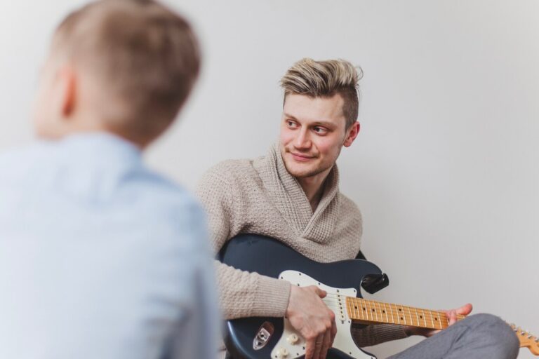 young-father-with-guitar-looking-side_23-2147624686